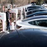 A Tesla supercharger station filled with electric cars.