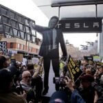 People participate in a "TeslaTakedown" protest against Elon Musk outside of a Tesla dealership in New York, March 1, 2025.
