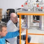 Scientists at Renaissance Fusion examine equipment.