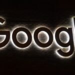 Google logo sign with white backlighting on dark background