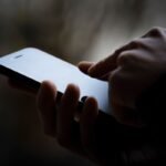 a photo of a person's phone in someone's hand, the image is darkened