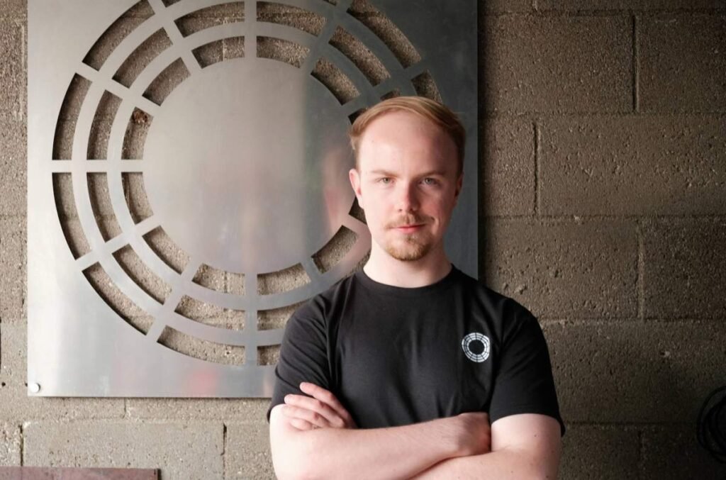 Durin founder Ted Feldmann stands before metal art.