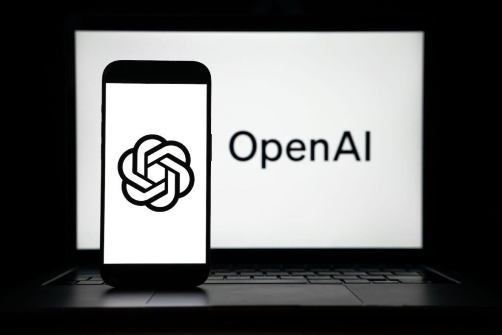 the logos of Open AI displayed on both computer and smart phone screen