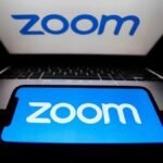 Zoom logos are seen displayed on a laptop and a phone screens in this illustration photo