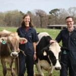 Hoofprint founders stand with two cows.