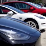 Tesla cars sit in a dealership lot