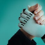 human hand an robot hand clasped for arm wrestling