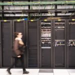 A visitor walks past a computer bay at the PA10 data center, operated by Equinix Inc., in Paris, France.