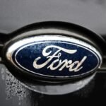 A Ford logo is seen on a gray car.