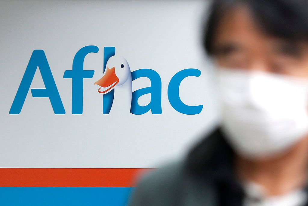 aflac's logo in the background, with someone wearing a mask in the foreground.
