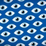 Illustrated patterned eyes on a blue background with a darkened vignette.