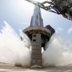 A view of SpaceX's starship system on the launchpad with the water-cooling flame deflector system active