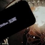 logo of ''Activision Blizzard'' is displayed on a mobile phone screen in front of a computer