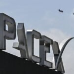 US billionaire businessman and pilot Jared Isaacman flies in formation aboard a fighter jet over the SpaceX sign, close to the Starship spacecraft, before his third test flight from Starbase in Boca Chica, Texas, on March 13, 2024. Elon Musk's SpaceX announced it was eyeing March 14 as the earliest date for the next test launch of its giant Starship rocket, with which it hopes to one day colonize Mars. Two previous attempts have ended in spectacular explosions, though the company has adopted a rapid trial-and-error approach in order to accelerate development. (Photo by CHANDAN KHANNA/AFP via Getty Images)