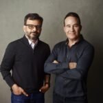 a picture showing the co-founders of Kana, Tom Chavez and Vivek Vaidya, leaning against a grey background