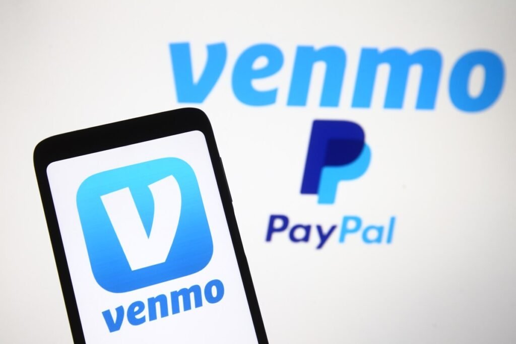 Venmo logo, a mobile payment service of PayPal is seen displayed on a smartphone and a PC screen.