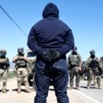 Federal agents block people protesting an ICE immigration raid at a nearby licensed cannabis farm on July 10, 2025 near Camarillo, California.