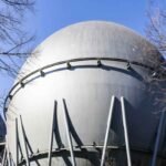 Industrial hydrogen storage tank stands against a blue sky.