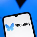 Bluesky logo appears on the screen of a smartphone
