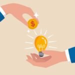 Crowd funding, new business or start up company to get money or venture capital to support or sponsor business concept, businessman hand giving money dollar coin to new business idea light bulb.