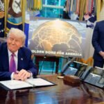 Golden Dome missile program placard with Trump sitting at desk