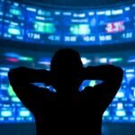 young man standing in front of the projection reflected stock market