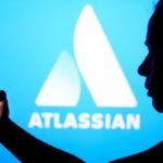 an Atlassian logo on a blue background with a person silhouetted in front holding a phone, for some reason