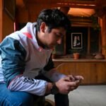 seated man looking at ell phone