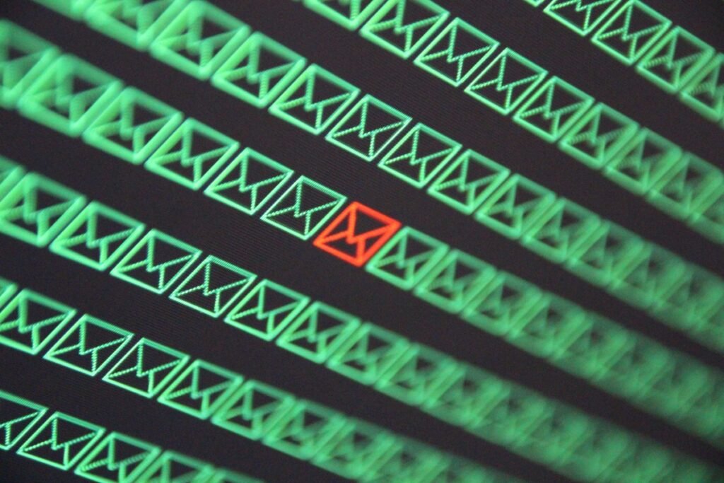 red email envelope in a sea of green email envelopes