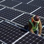 A man inspects solar panels.
