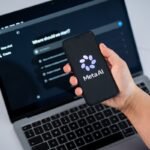 The Meta AI logo is seen on a smartphone screen, and a chatbot website is displayed on a computer screen.