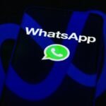 The WhatsApp logo is displayed on a mobile phone screen in this photo illustration.
