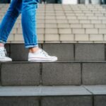 Young woman with backpack going down a staircase.